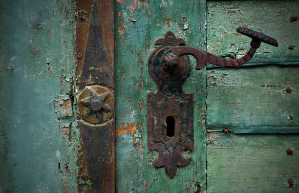 Rusty door handle with star ornament on a green painted old gate.
