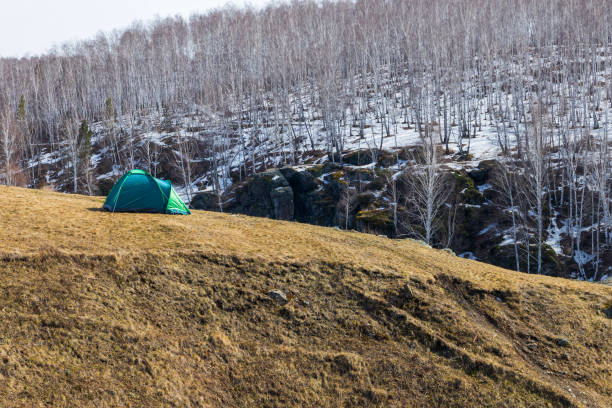 green tent on the slope in spring. travel through the spring forest. unity with nature. rest from the city