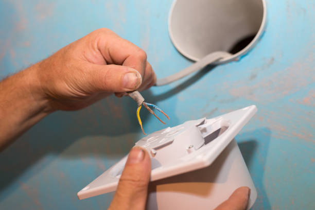 istock Man is installing the wall bathroom fan vent. Restoration process. Wires in hands. Maintenance repair works renovation in the flat. 1346199030