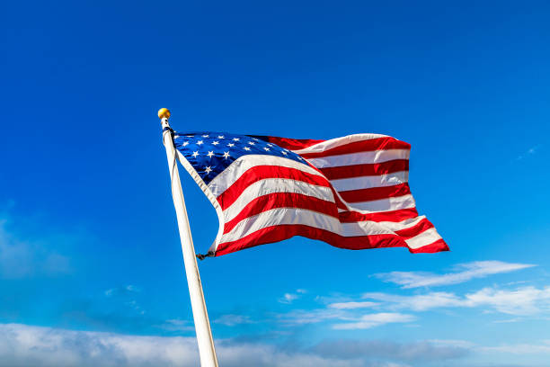 USA flag waving against sky USA flag waving against sky with beautiful cloud flagpole stock pictures, royalty-free photos & images