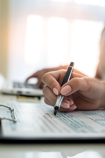 female hand filling us tax form, 1040. taxation concept