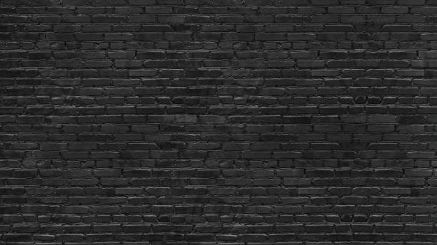 istock Old rough black brick wall large texture. Dark grey brickwork masonry backdrop. Gloomy grunge abstract background 1346200509