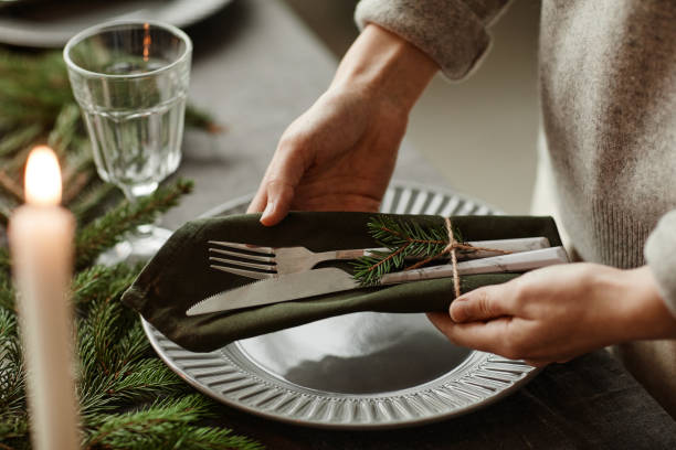 istock Woman Setting Elegant Plates on Christmas Table 1346201583