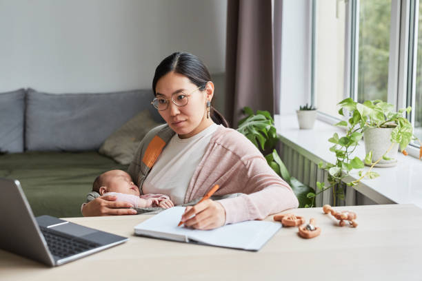 istock Woman studying with her baby on hands 1346203484