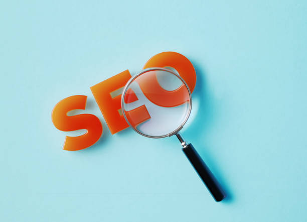 istock Magnifier And SEO Text On Aquamarine Background 1346203814