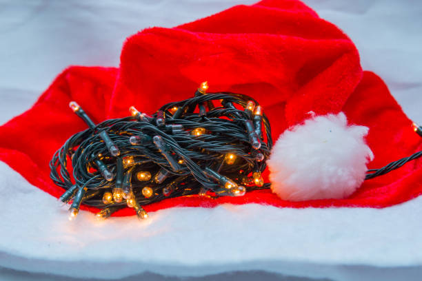 istock Christmas decorative lights with a red hat on a white background 1346205106