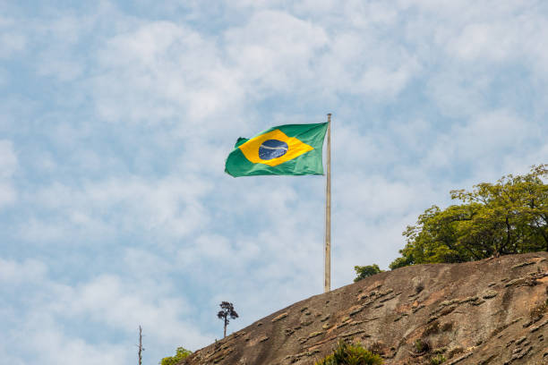 istock brazil flag outdoors with a beautiful blue sky 1346206031