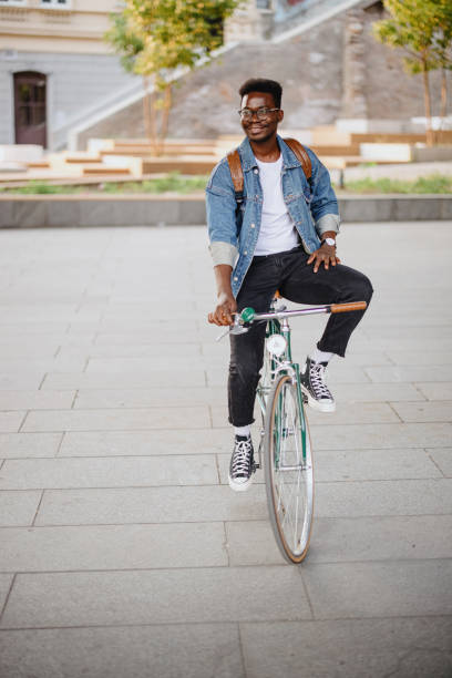 istock Young man traveling with a bicycle through the city 1346206126