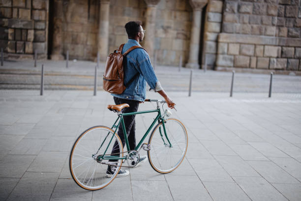 istock Young man walking with his bicycle in an urban location 1346206191