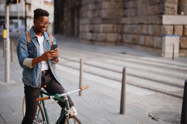 istock Handsome man sitting on the bike using smartphone for text messages 1346206346