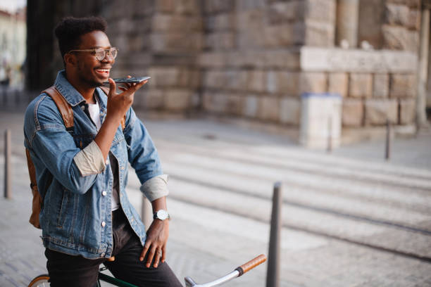 istock Handsome man sitting on the bike  using smartphone for voice assistant 1346206348