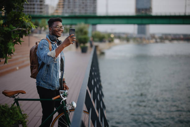 istock Young man taking photos at sunset standing on the pier watching the river 1346206648