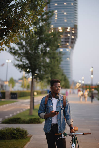 istock Young man walking with his bicycle on a walkway at night 1346206874