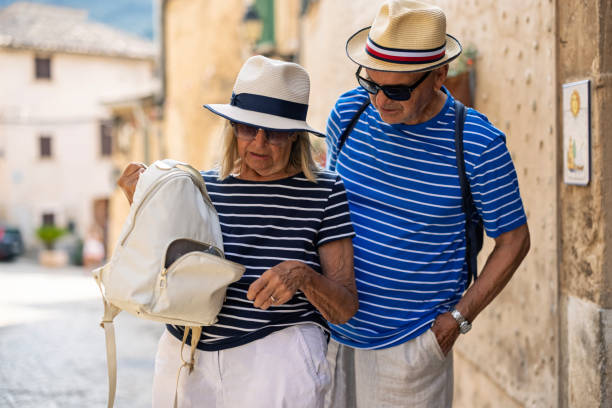 Senior tourist couple discovering missing wallet Senior couple sightseeing a town on summer vacations. The couple is discovering and open backpack and missing wallet. Canon R5 pickpocketing stock pictures, royalty-free photos & images