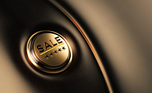 Gold colored sale written car start button on dashboard. Horizontal composition with copy space and selective focus. Sale concept.