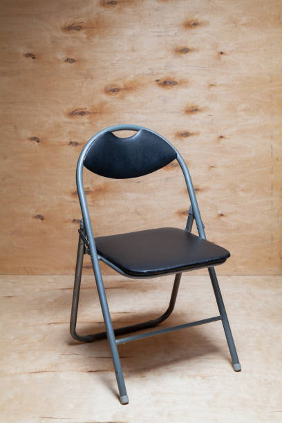 istock Folding chair stands on wooden background 1346208613