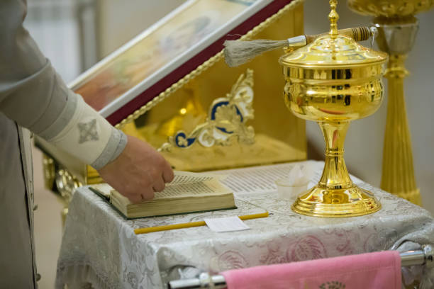 las manos del sacerdote están volviendo la biblia - sotana fotografías e imágenes de stock