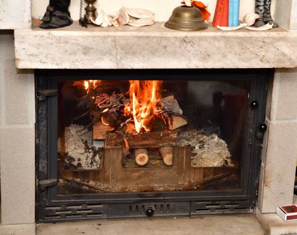 llamas de un fuego ardiente en una chimenea insertadas en una cabaña - chimney sweeping fotografías e imágenes de stock