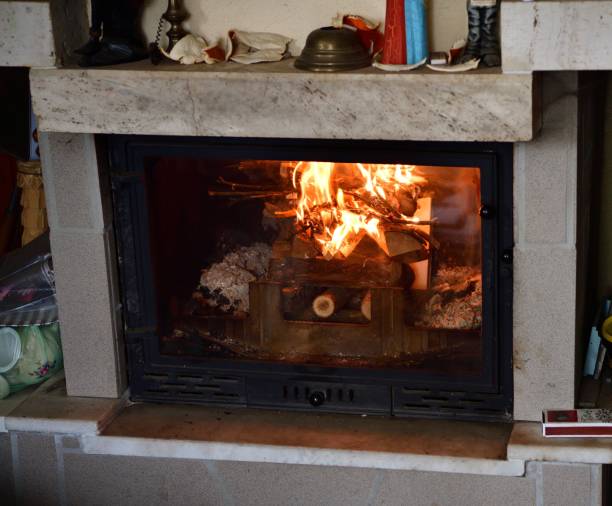 View of a brick home fireplace with a blazing fire in the cottage