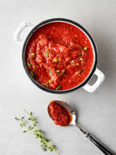 salsa de tomate casera en la cacerola, cocinar y condimentar salsa de tomate, pasta de tomate, preparación de salsa de tomate fresco, - salsas aderezo fotografías e imágenes de stock