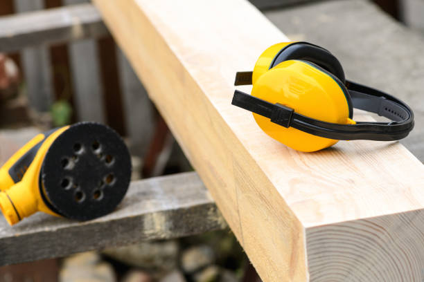 istock Protective earmuffs and eccentric orbital sander, grinder machine on a wooden surface 1346215056