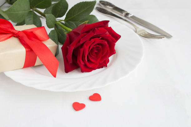 istock Festive table setting for Valentine's day with red rose and gift box. Close-up. 1346215417
