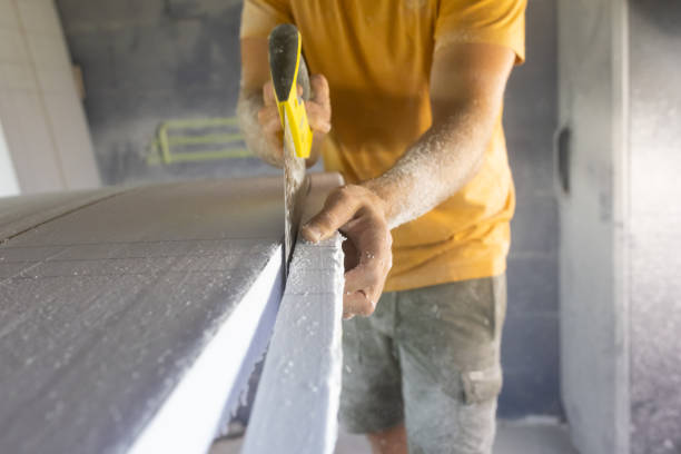 istock Surfboard making, woodworker wearing safety respirator sawing surfboard blank using handsaw 1346220436