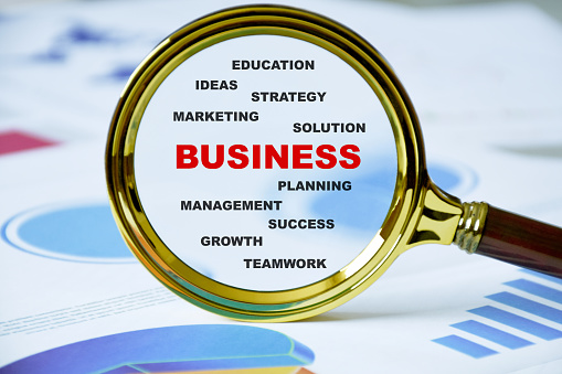 Business concept. Business words in the magnifying glass with business documents