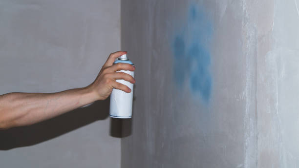 istock Spray can in hand. spraying paint on the wall. painting process 1346222848