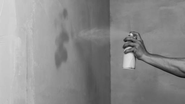 istock Spray can in hand. spraying paint on the wall. painting process 1346222886