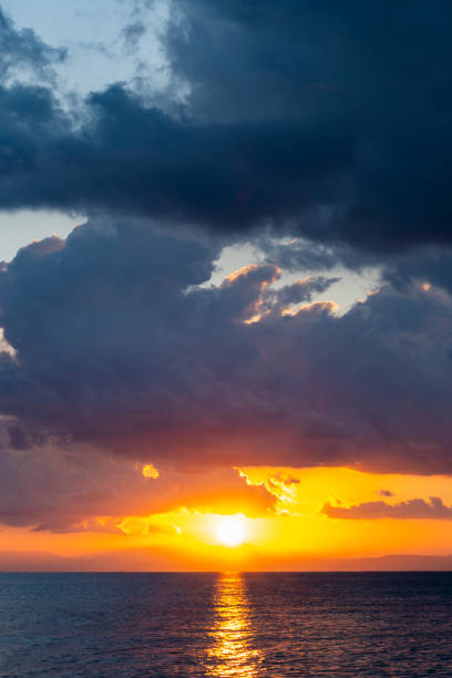 Stunning dramatic, cloudy sunrise with a bright sun rising over a calm water. Natural background, Sardinia, Italy.