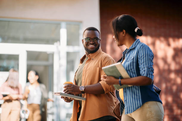 istock Happy African American students talking while walking on a class at the university. 1346225714