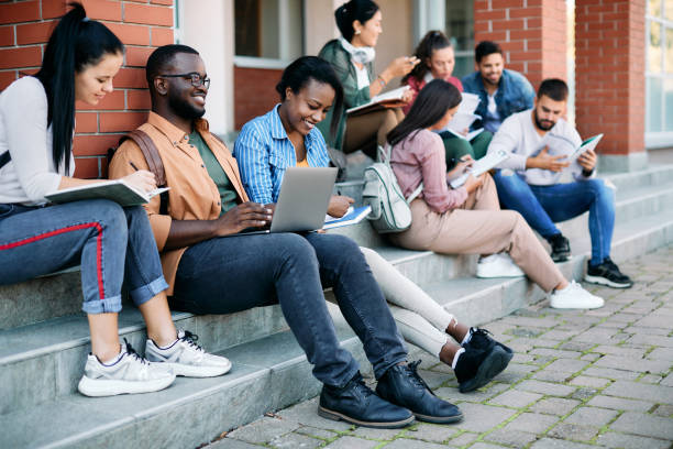 istock Happy college student learning together outdoors at campus. 1346226067
