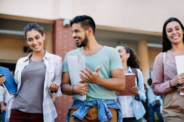 istock Group of cheerful students talking while walking outdoors after the lecture. 1346226190