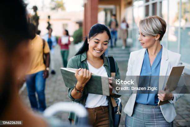 University Teacher Talking To Her Asian Female Student At Campus Stock Photo - Download Image Now