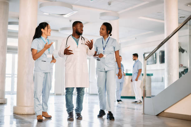 istock Full of young students communicating while walking through medical university hallway. 1346227044