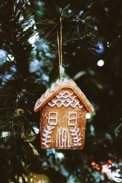 Gingerbread house hanging on the Christmas tree. New Year festive decoration. Christmas magic atmosphere Christmas Tree Cookie stock pictures, royalty-free photos & images