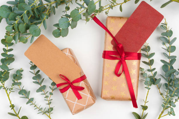istock Gift boxes packed in craft paper with simple decor of green plant branches 1346229980