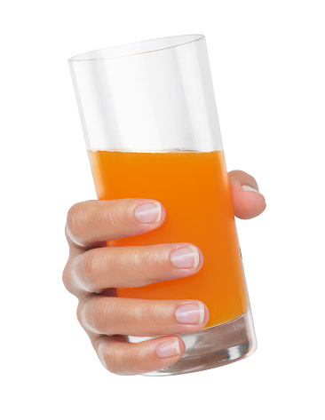 Hand holding orange juice glass isolated on white background.
