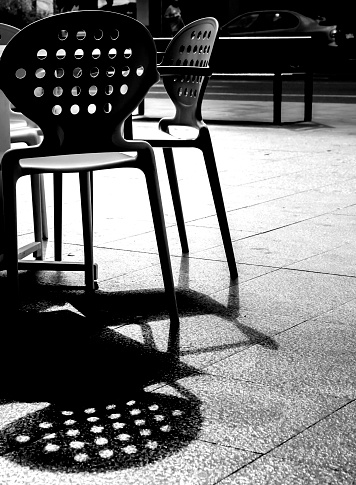 Empty table and chairs of a restaurant in Spain. Monochrome picture