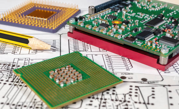 istock Electronic board, pen, and processors  on background of  schematic circuit diagram and a photomask for manufacture of printed circuit boards. Concept for development and design of electronic devices. 1346235400