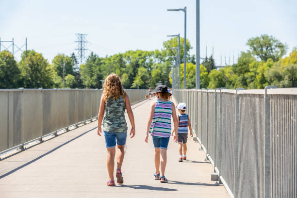istock Three Kids Walking Across Bridge Over Dam 1346237096