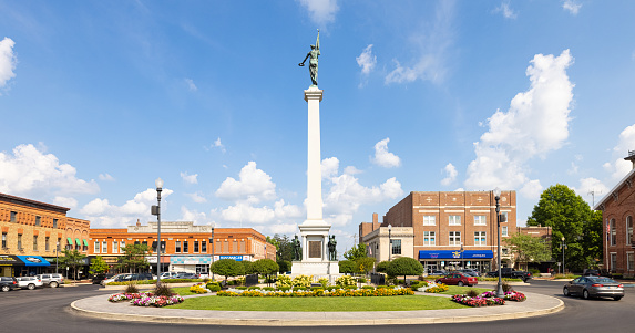 Angola, Indiana, USA - August 21, 2021: The Steuben County Soldiers Monument in downtown, with the old business district buildings