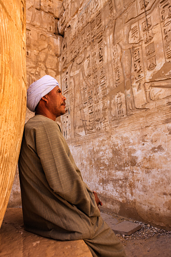 Egyptian man looking at hieroglyphs in ancient temple and admires , Egypt