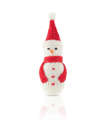 Knitted Christmas snowman in red hat and scarf isolated on a white background, with shadow and reflection.