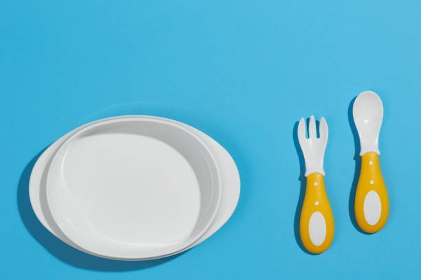 istock Flat composition with plastic accessories for baby food on an isolated light background. Serving baby, first feeding concept. Baby food accessory 1346240923