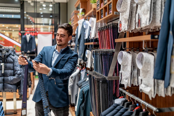 portrait of handsome young man buying clothes in the store. - shirt necktie men businessman imagens e fotografias de stock