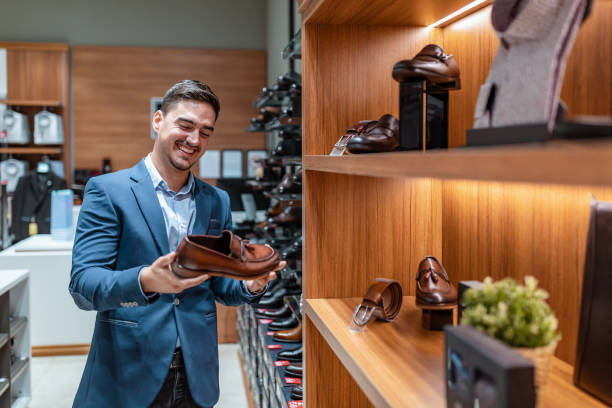 man  choosing classic shoes while doing shopping in the male store - shoe store shoe shopping retail imagens e fotografias de stock