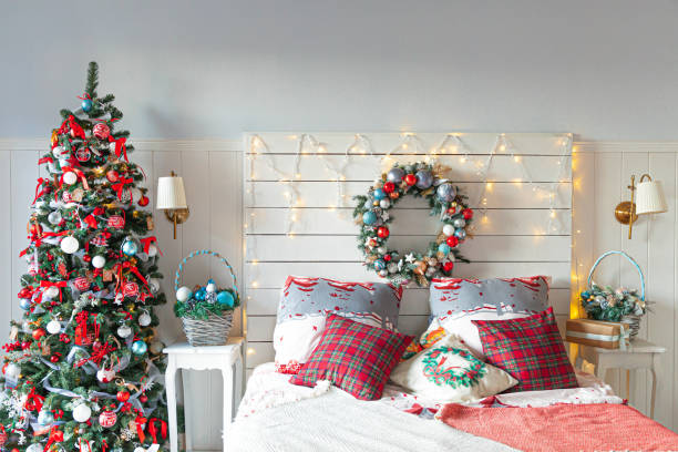 istock Classic interior room with Christmas tree and traditional white red decorations. Modern clean white classical style interior design apartment bedroom. Christmas eve at home. Minimalist home design 1346242130
