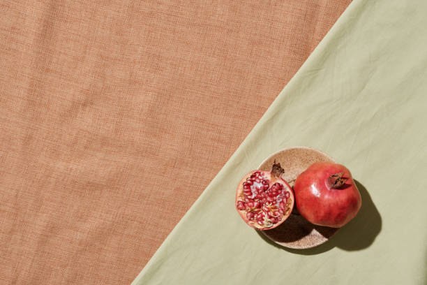 istock High angle view of fresh pomegranate and its piece on ceramic plate placed on tablecloth 1346244149